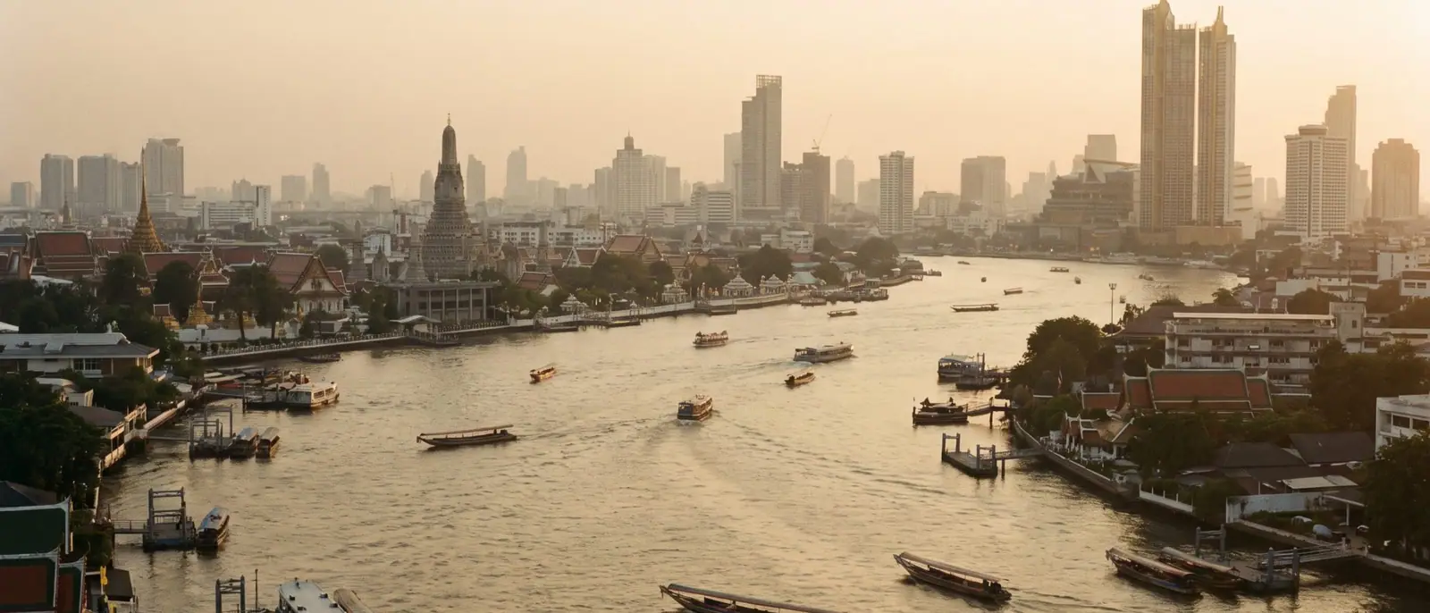 แม่น้ำเจ้าพระยายามพลบค่ำ มีเรือหางยาวบนผืนน้ำ และวัดอรุณอยู่ฝั่งตรงข้าม