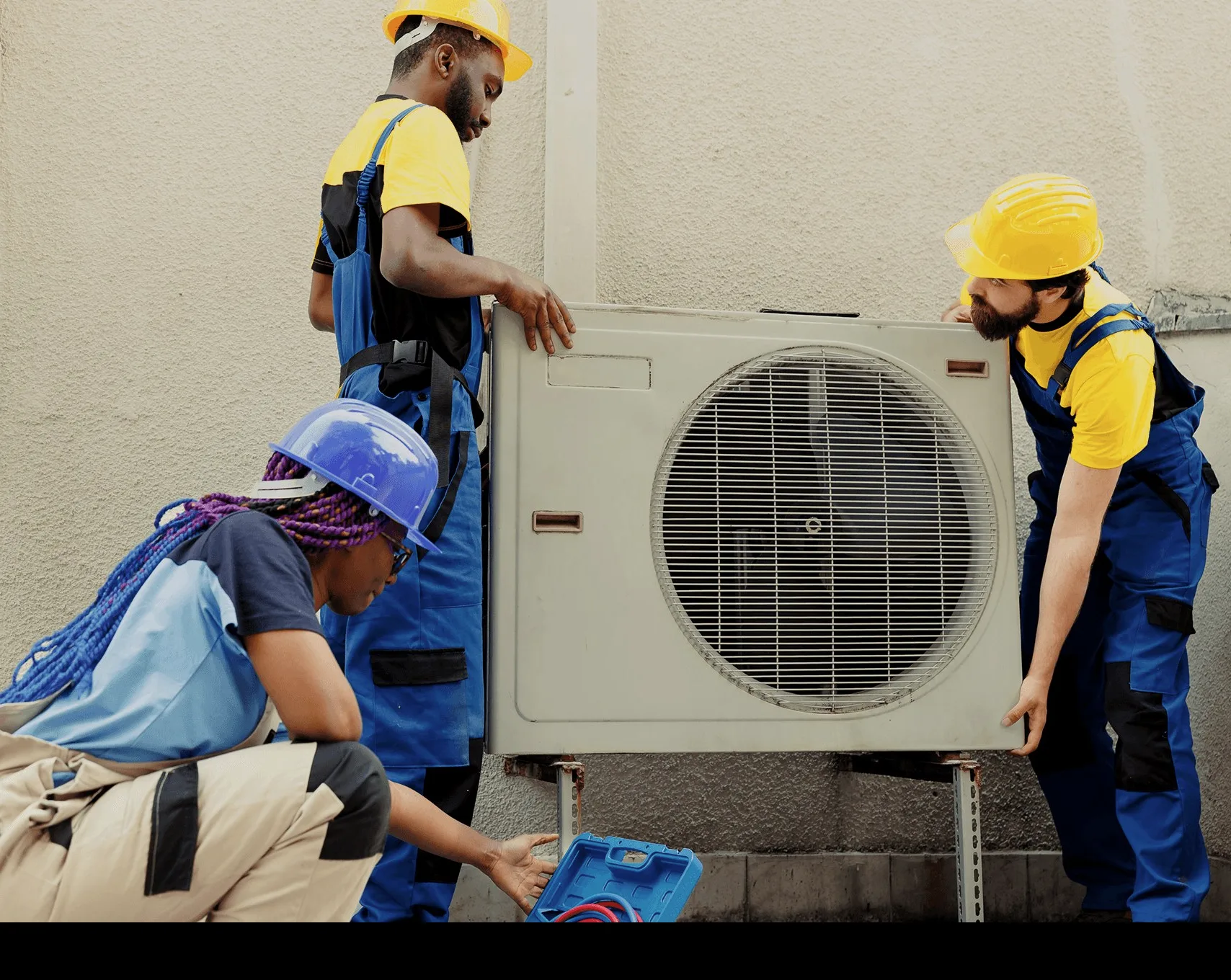 Two technicians setting an outdoor unit on its bracket.