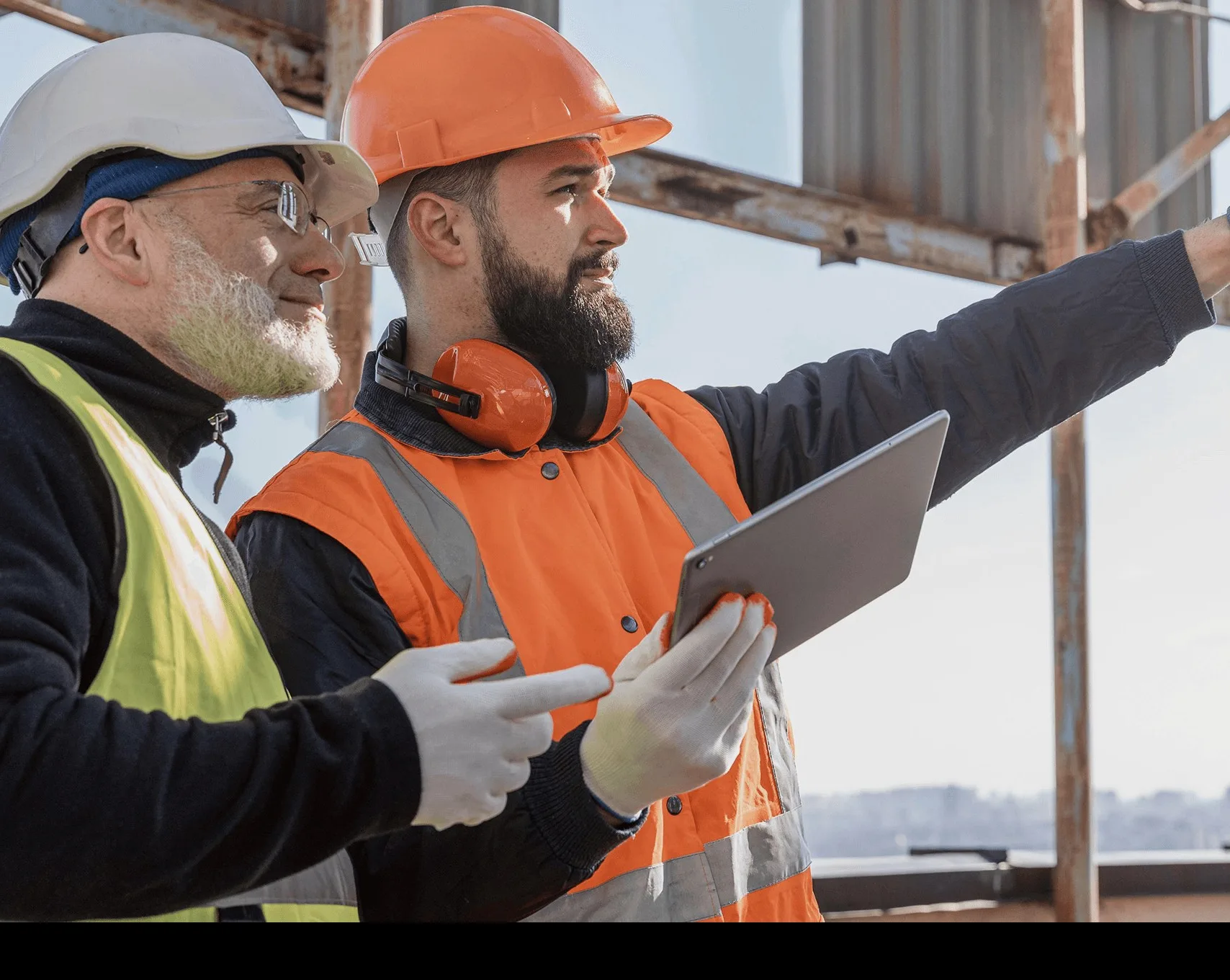 Two workers in high-visibility jackets with a tablet.