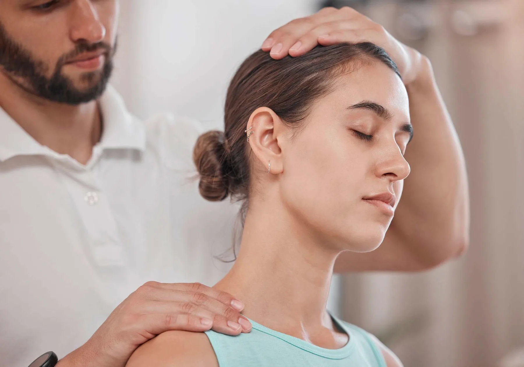 A woman's neck being stretched by a therapist.