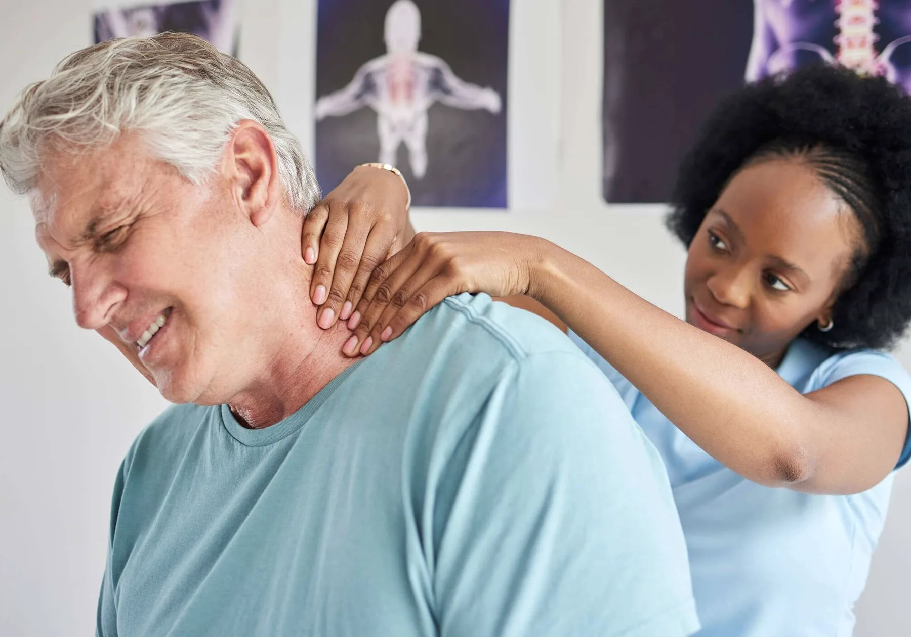 A chiropractor's hands on an older man's neck.