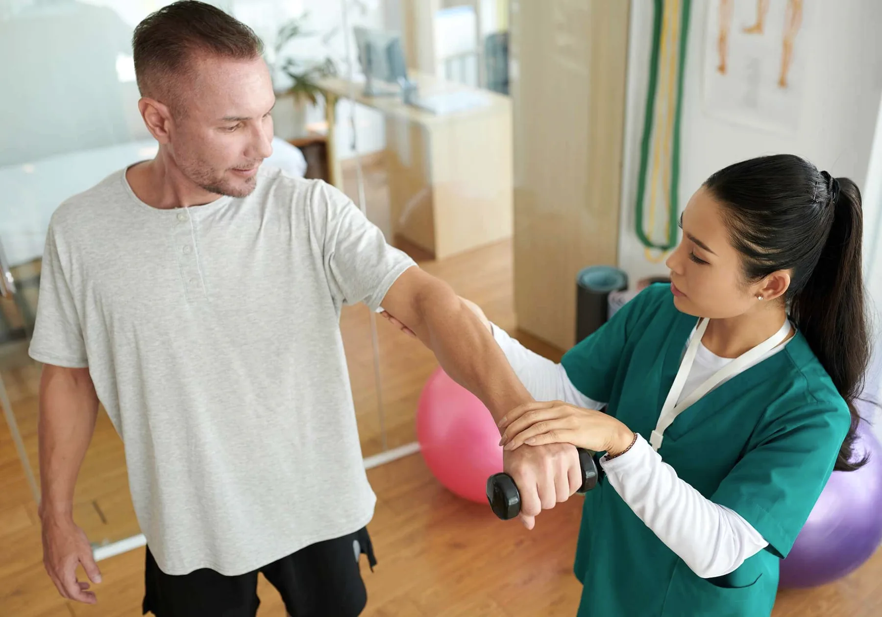 A rehabilitation specialist with a patient at a desk.