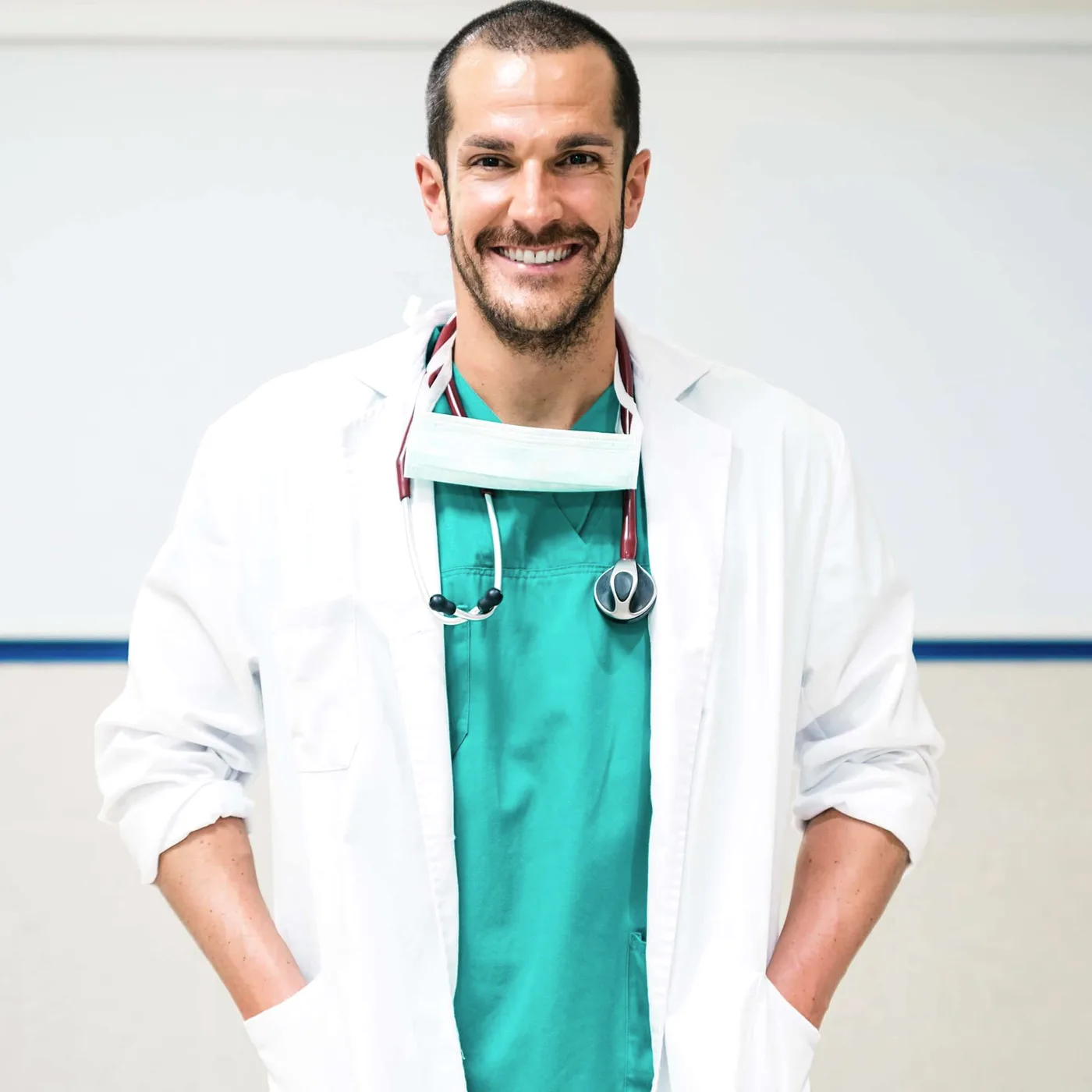 A smiling man in a white coat with a stethoscope.