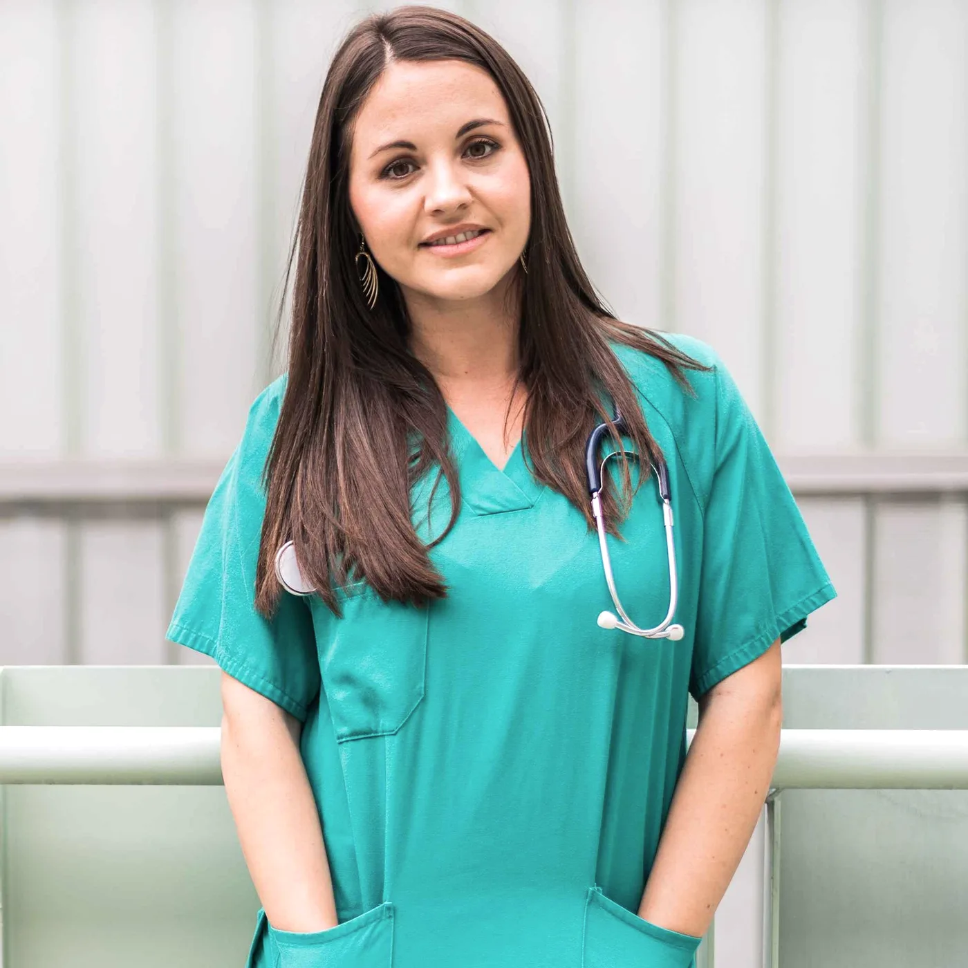 A smiling woman in green scrubs.