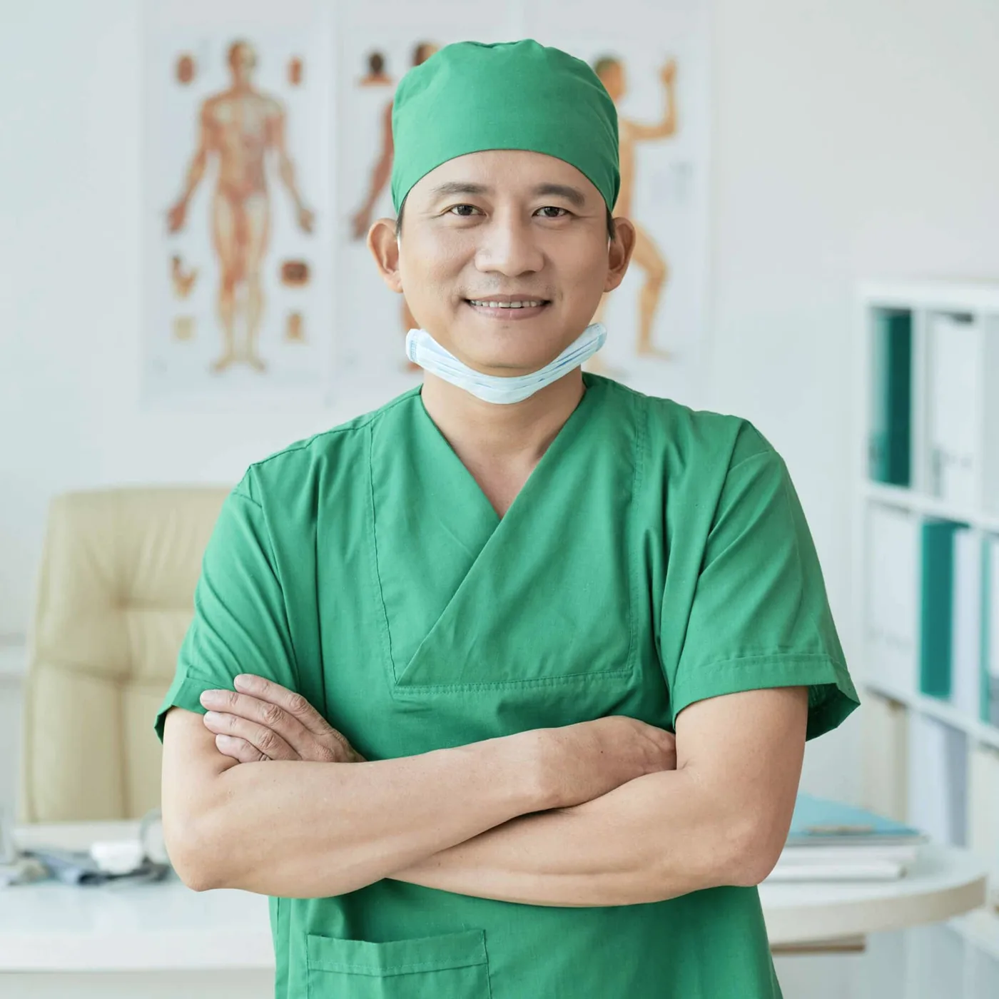 A man in a green surgical cap and mask.