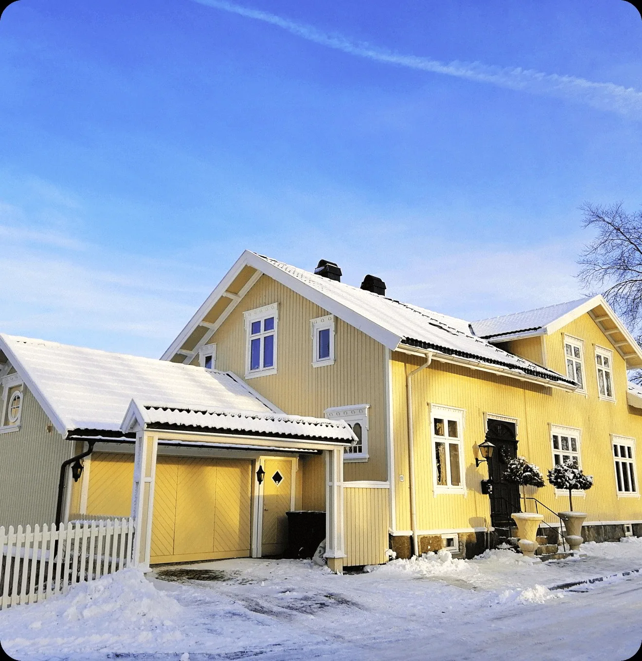 A yellow wooden house under snow.