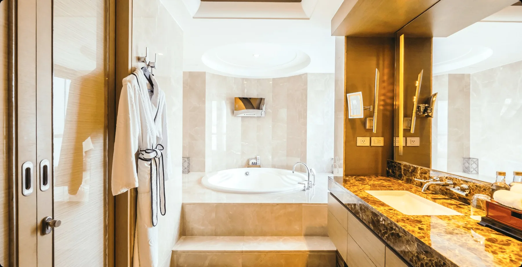 A marble bathroom with a bathrobe on a hook.
