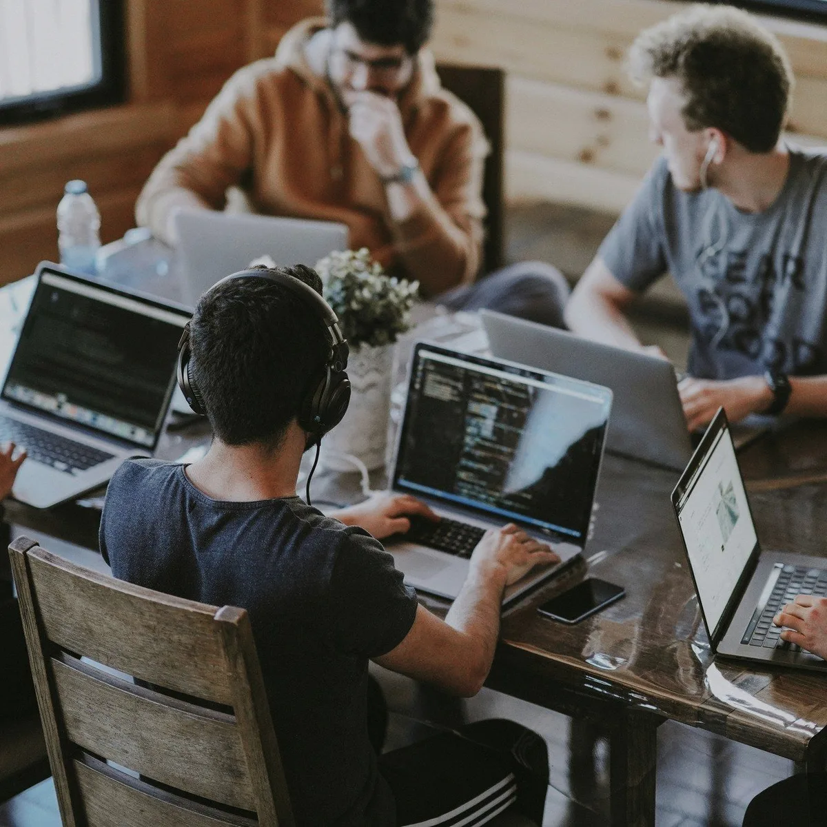 A coworking table full of laptops.