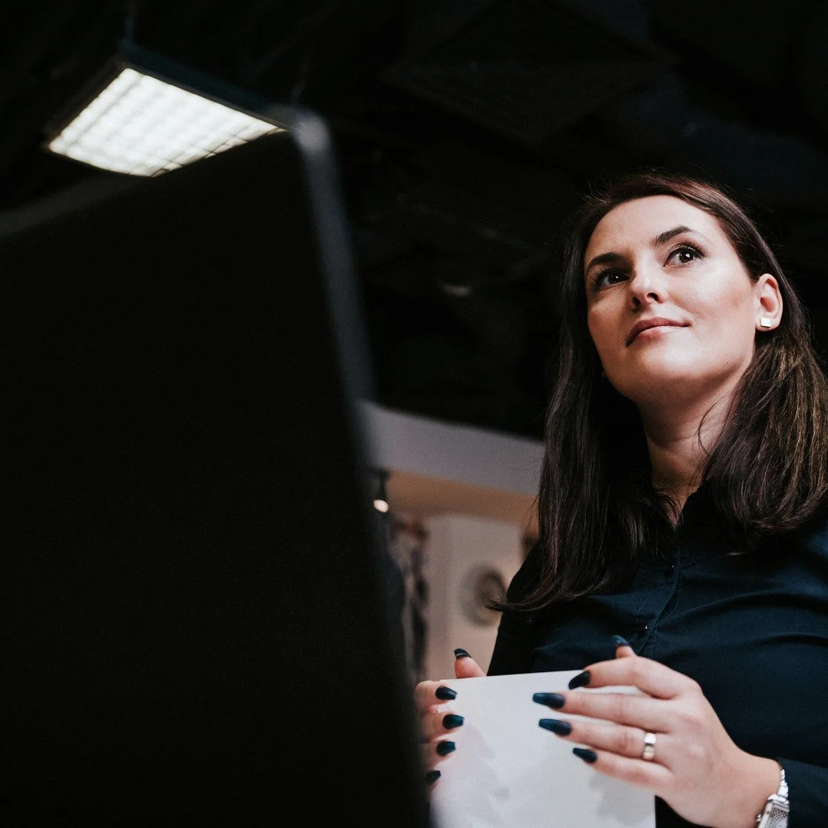 A woman looking up in a dark room.