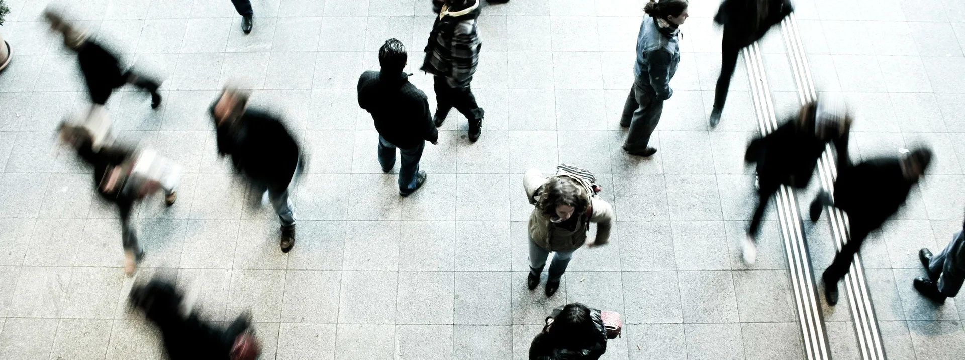 A crowd crossing a plaza, seen from above.
