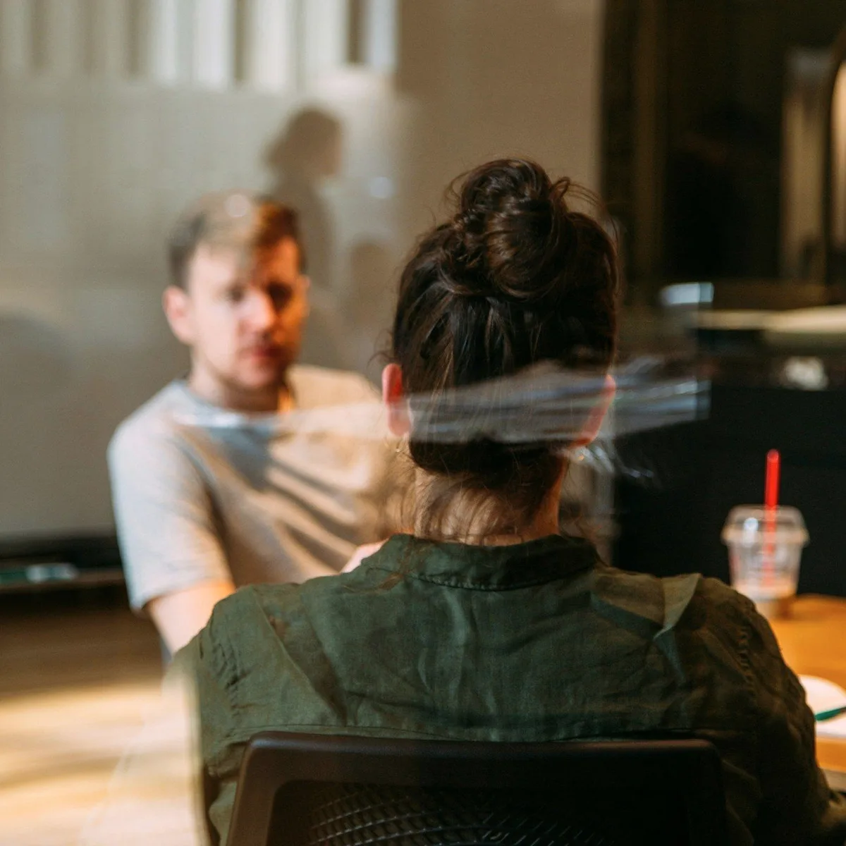 A woman seen from behind in a meeting.