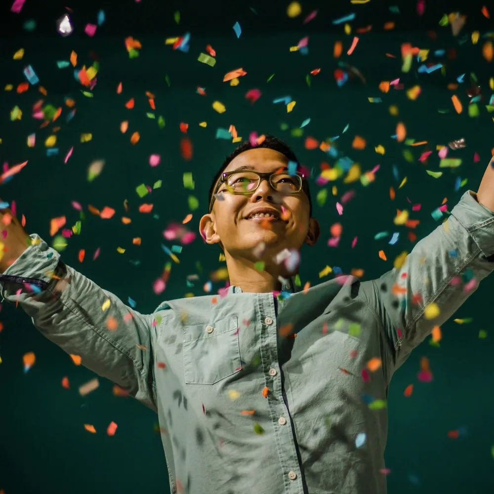 A person under falling confetti.