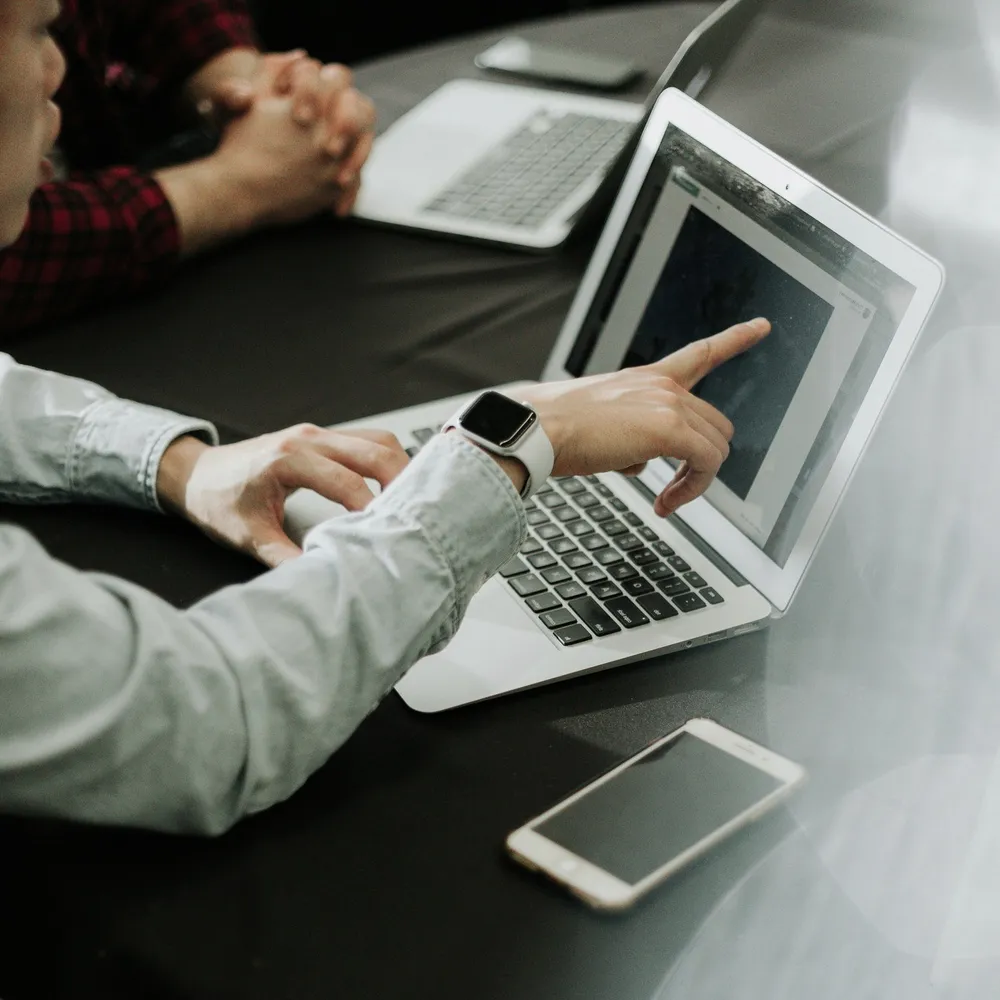 Hands on a laptop at a table.