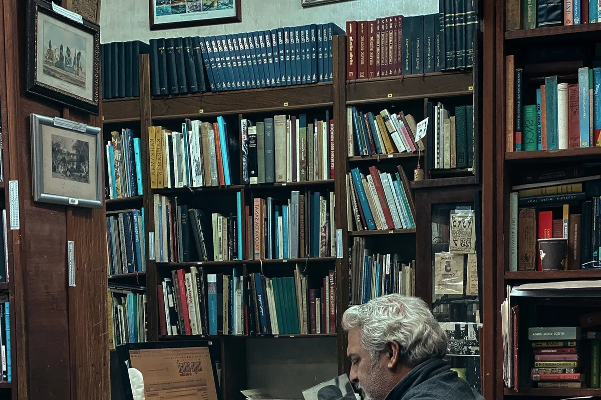 A man at a desk among books.