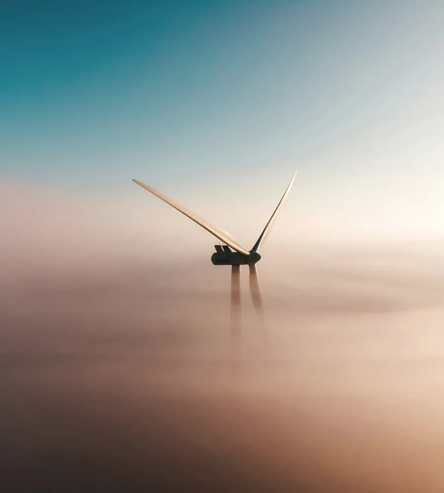 A wind turbine over the sea in haze.
