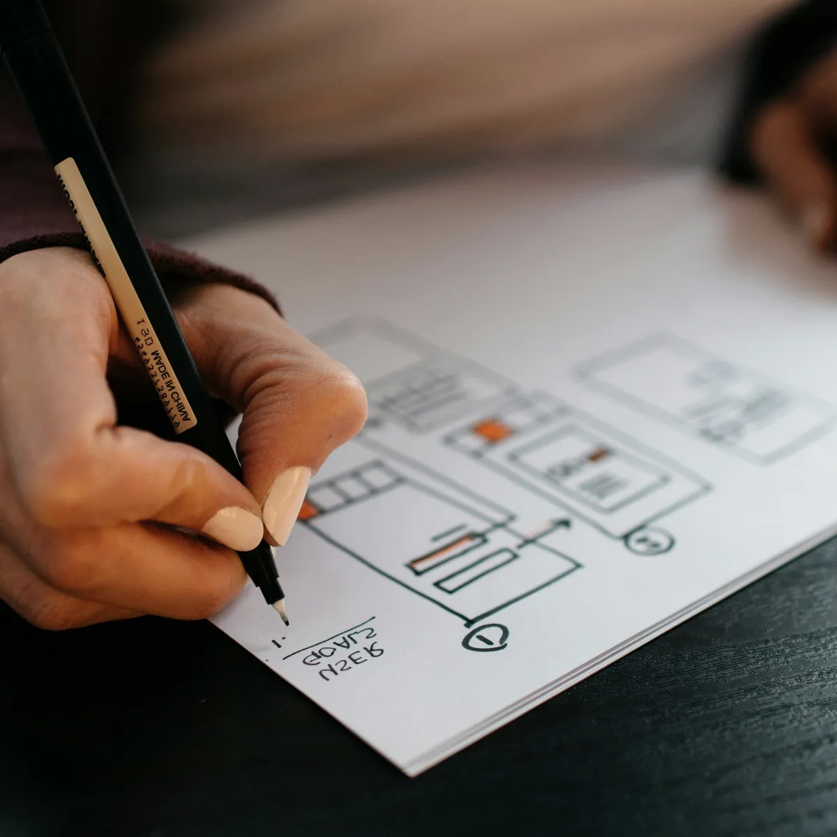 A hand sketching a plan on paper.