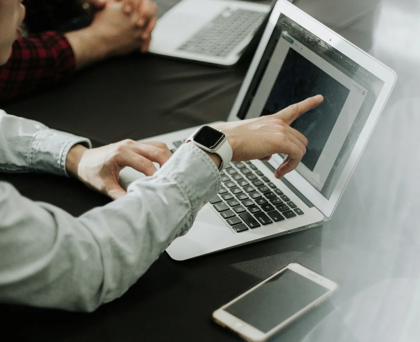 Hands on a laptop at a table.