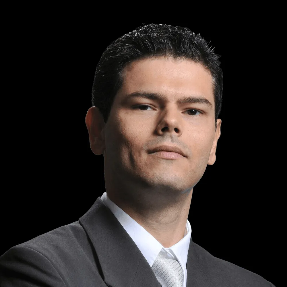 A man in a suit, smiling.