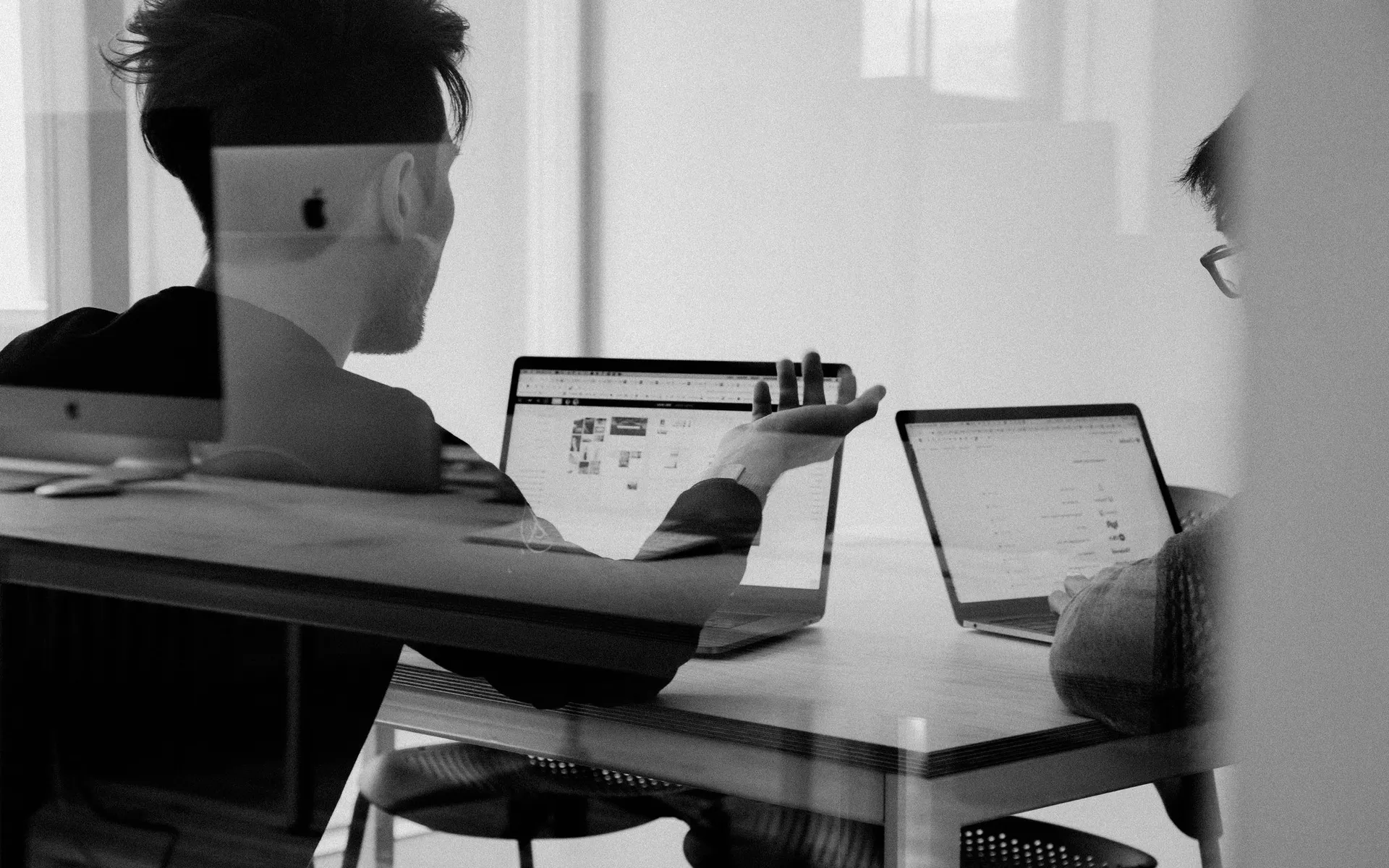 A man at a laptop in a dark room.