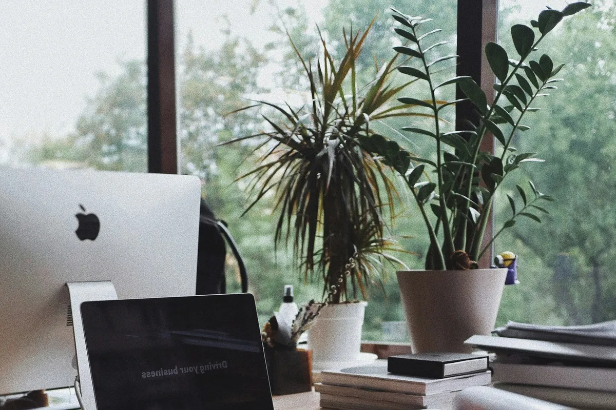 A laptop and papers on a desk.