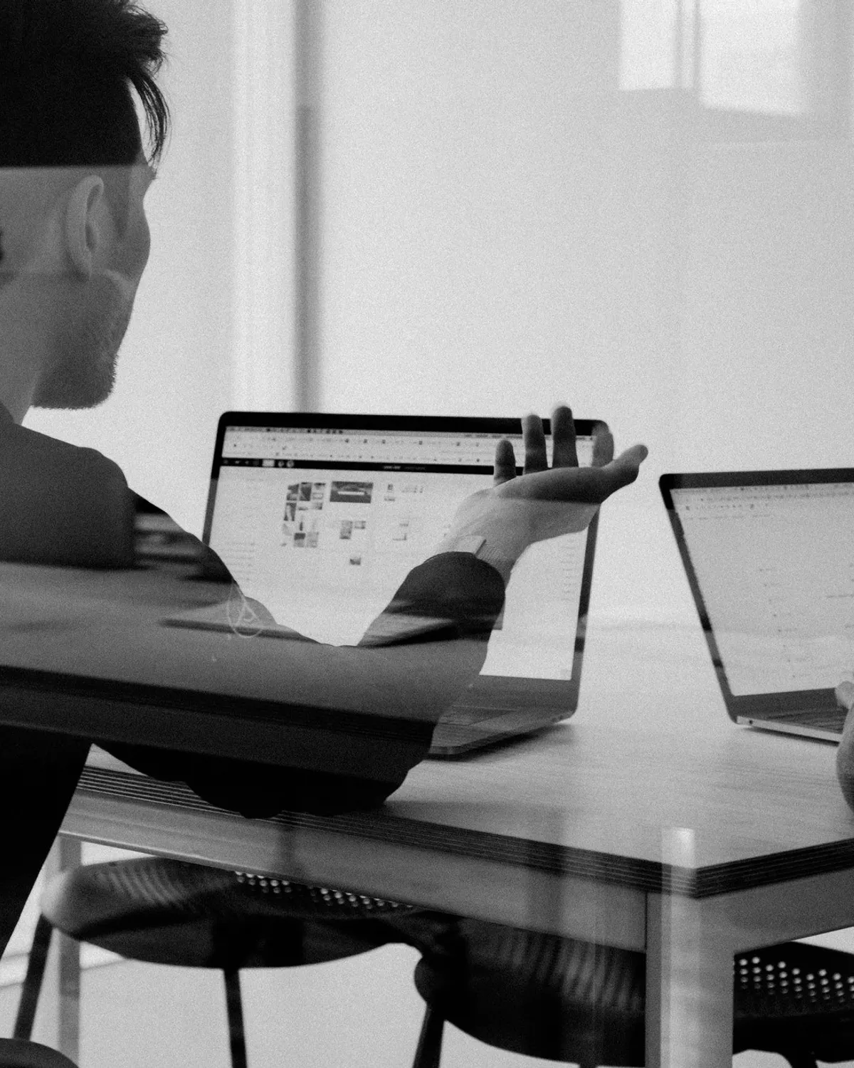 A man at a laptop in a dark room.