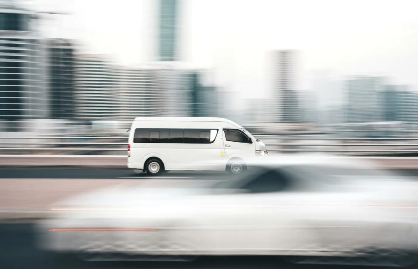 A white van in motion through a city.