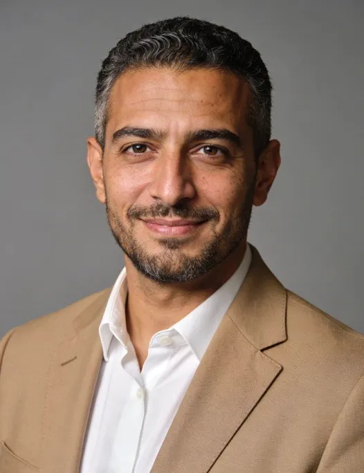 A man in a tan jacket.