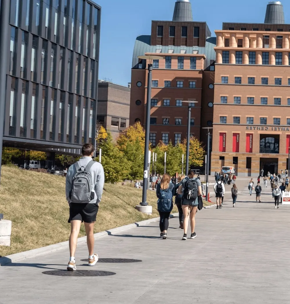 Students walking across campus in autumn.