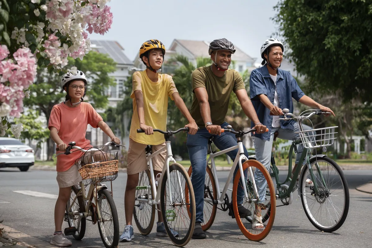Four cyclists on a tree-lined street.
