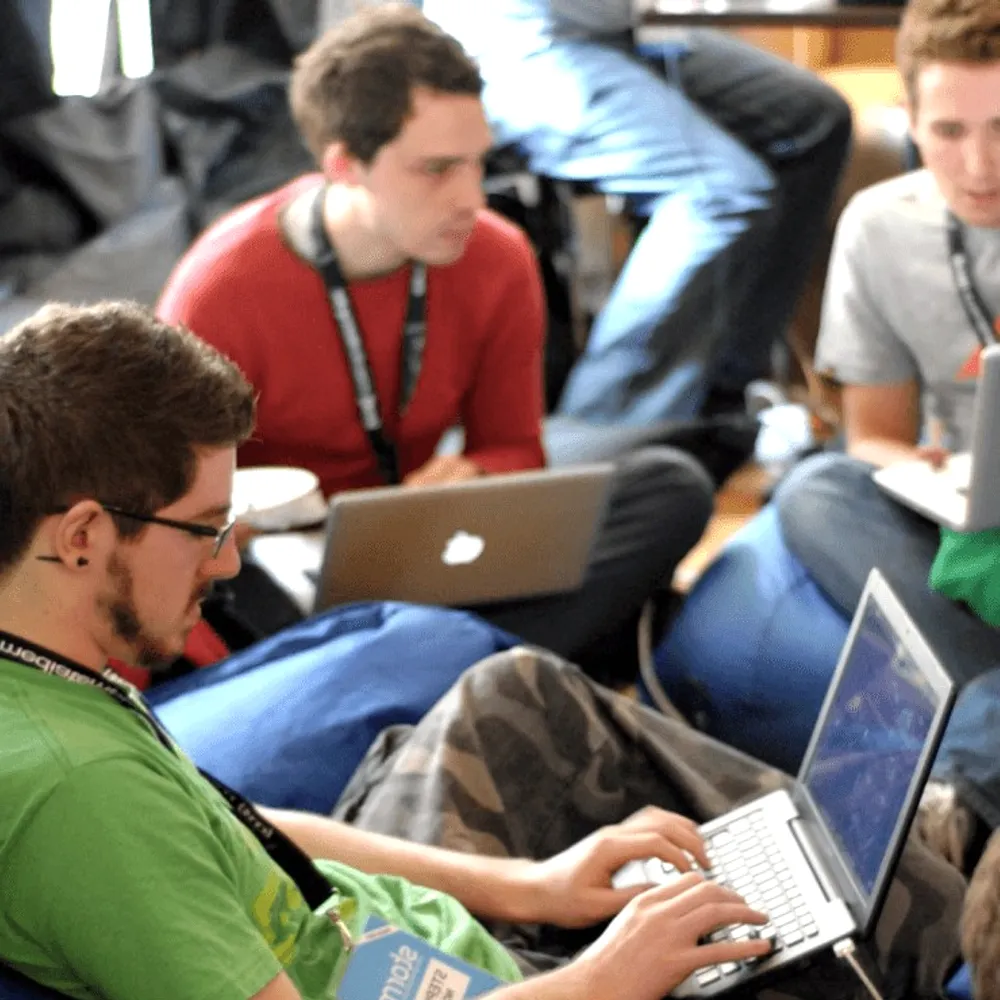 Students on bean bags with laptops.