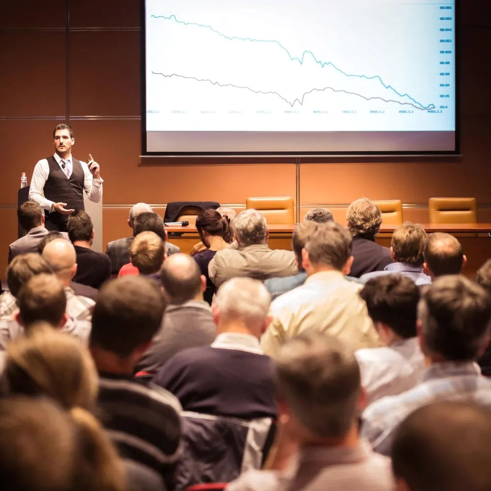 A speaker before a full auditorium.