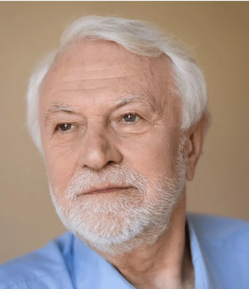 A white-bearded man in a blue shirt.