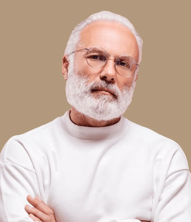 A man in a white jumper, arms crossed.