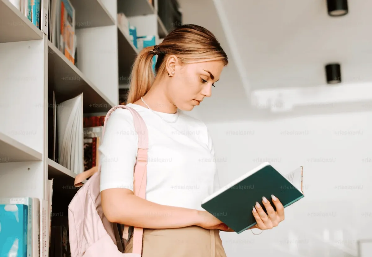 A student reading in the library stacks.