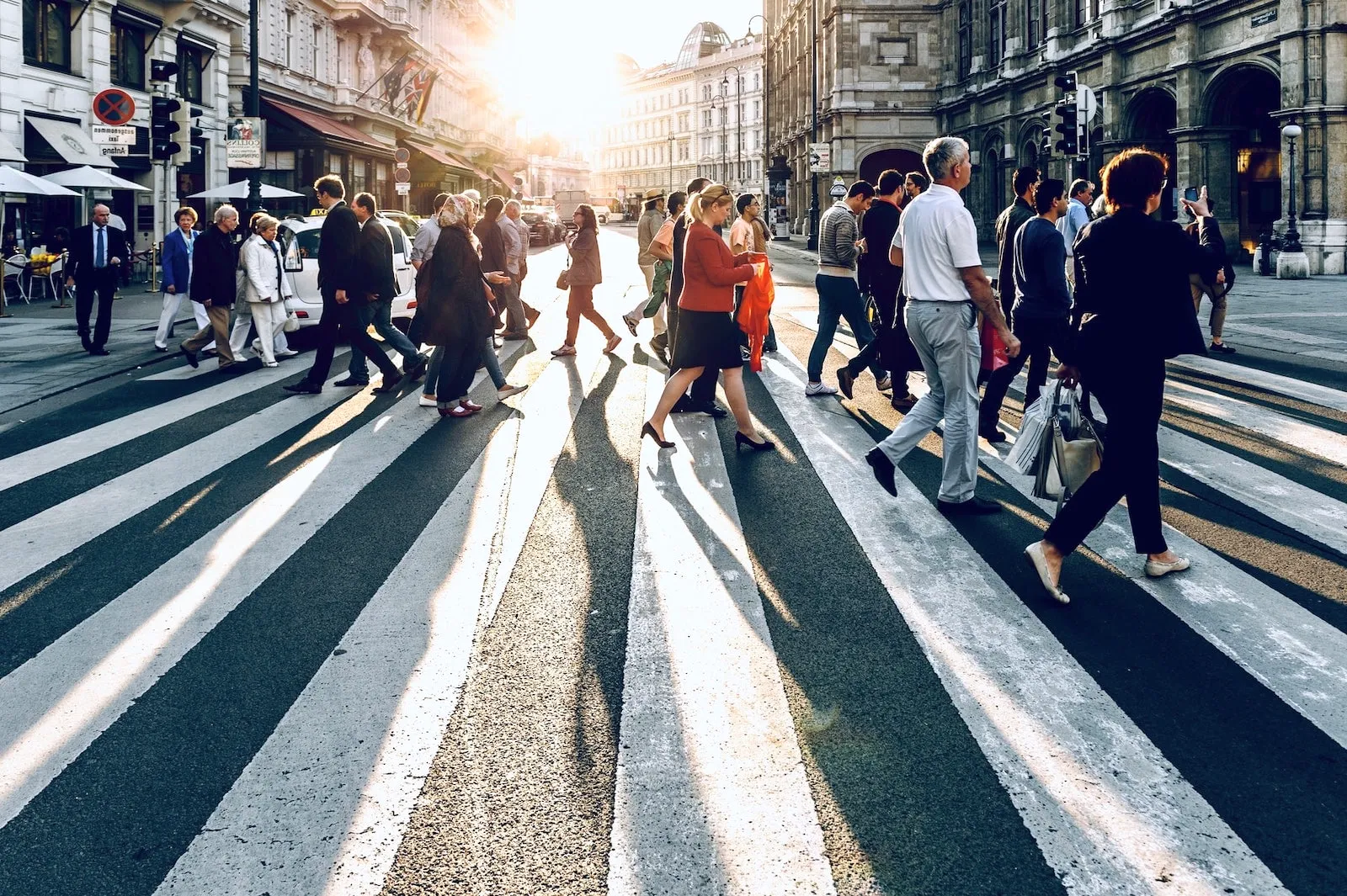 People crossing a sunny street in the city.