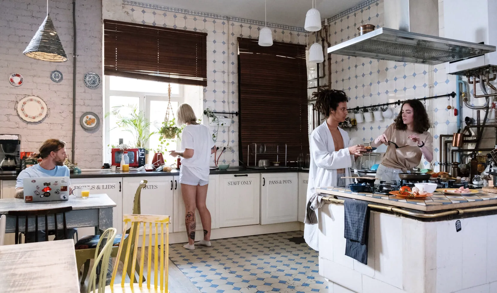 Guests cooking and talking in the shared kitchen.