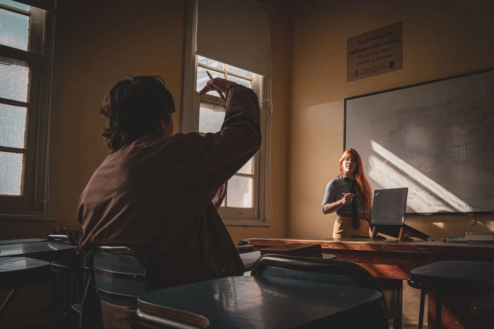 A language lesson in progress in a small room, teacher and student at one table in natural light.