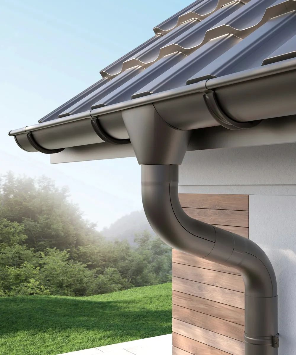 A grey gutter on a tiled edge in mist.