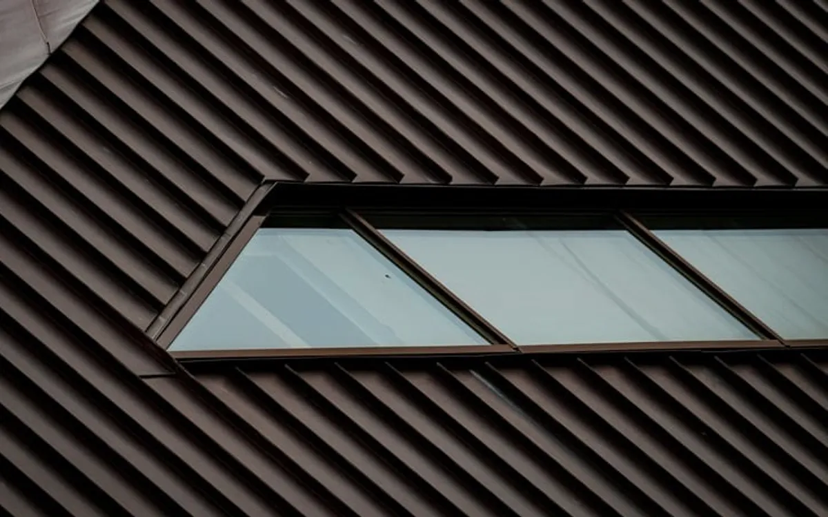 A dark metal roof with a window.