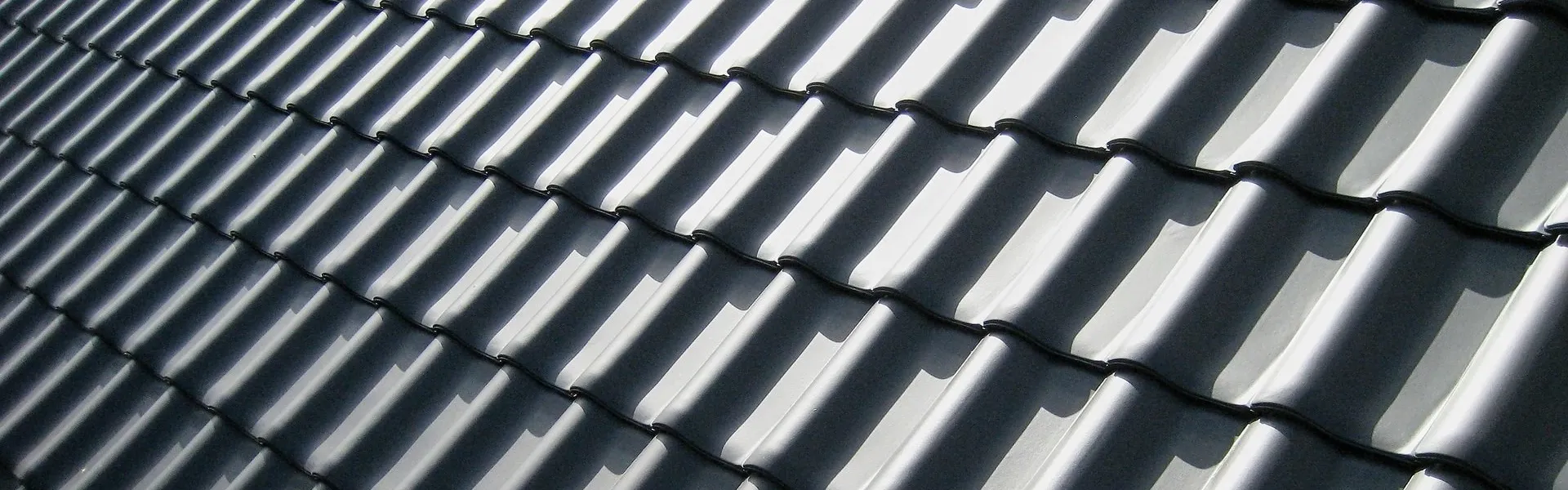 Dark tiles on a roof, close.