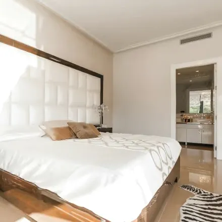 A bright bedroom with a tufted headboard and white linen.