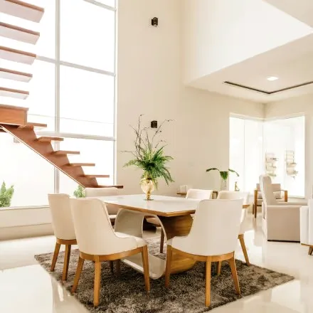 An open dining area with a wooden table and white chairs.