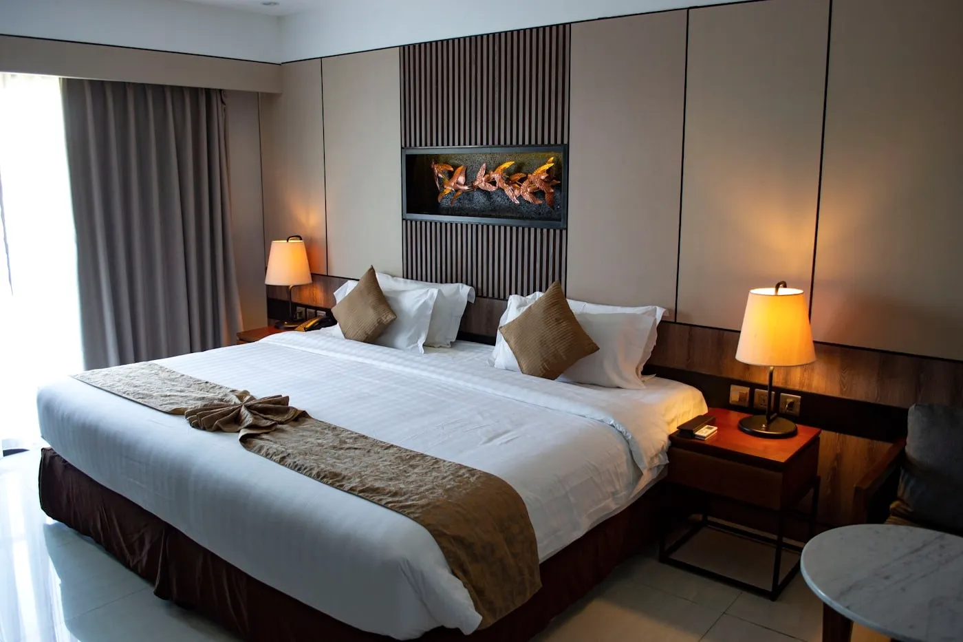 A room with a lamp and a bed with a runner.