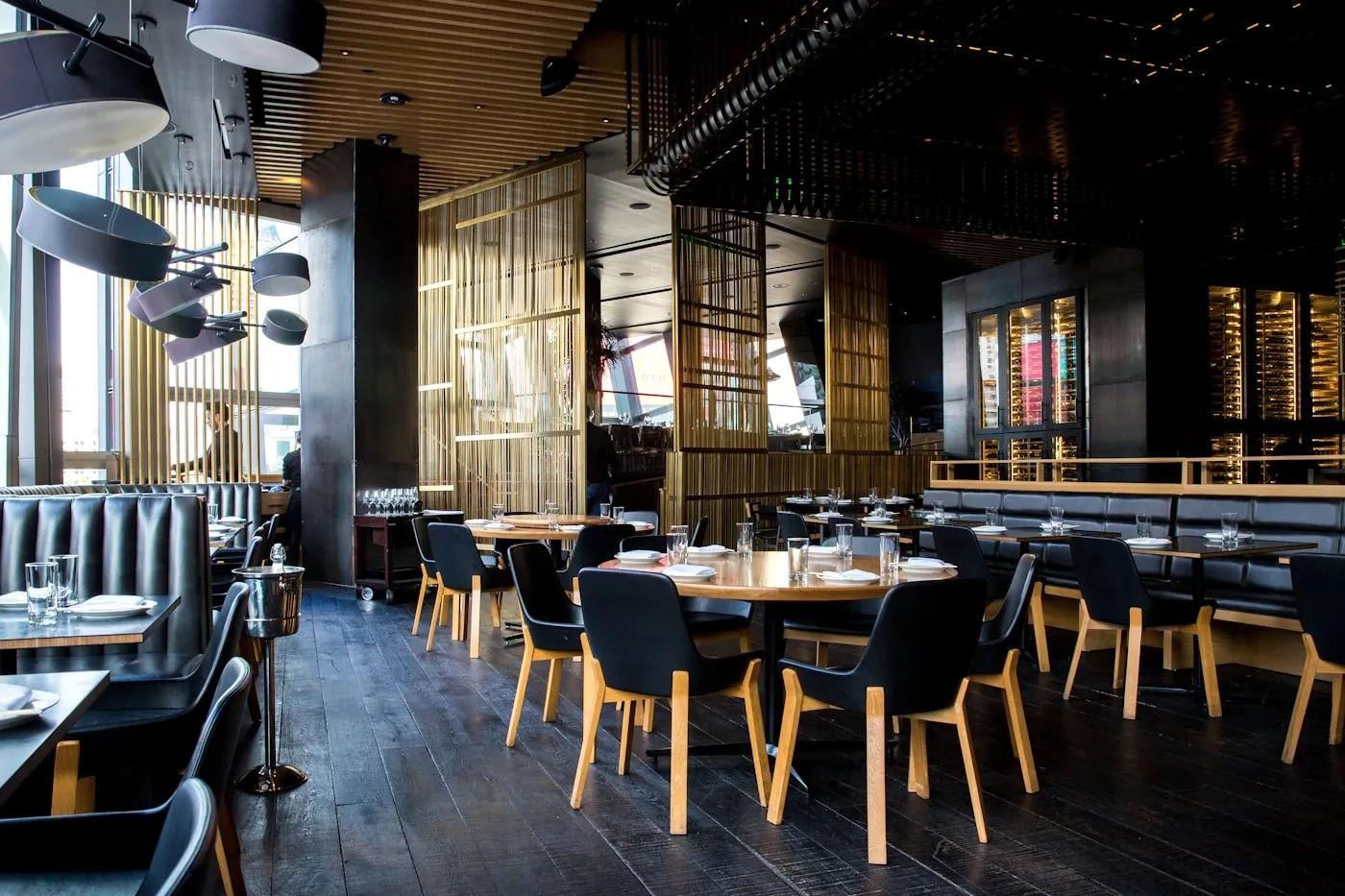 A restaurant with dark tables and lattice screens.