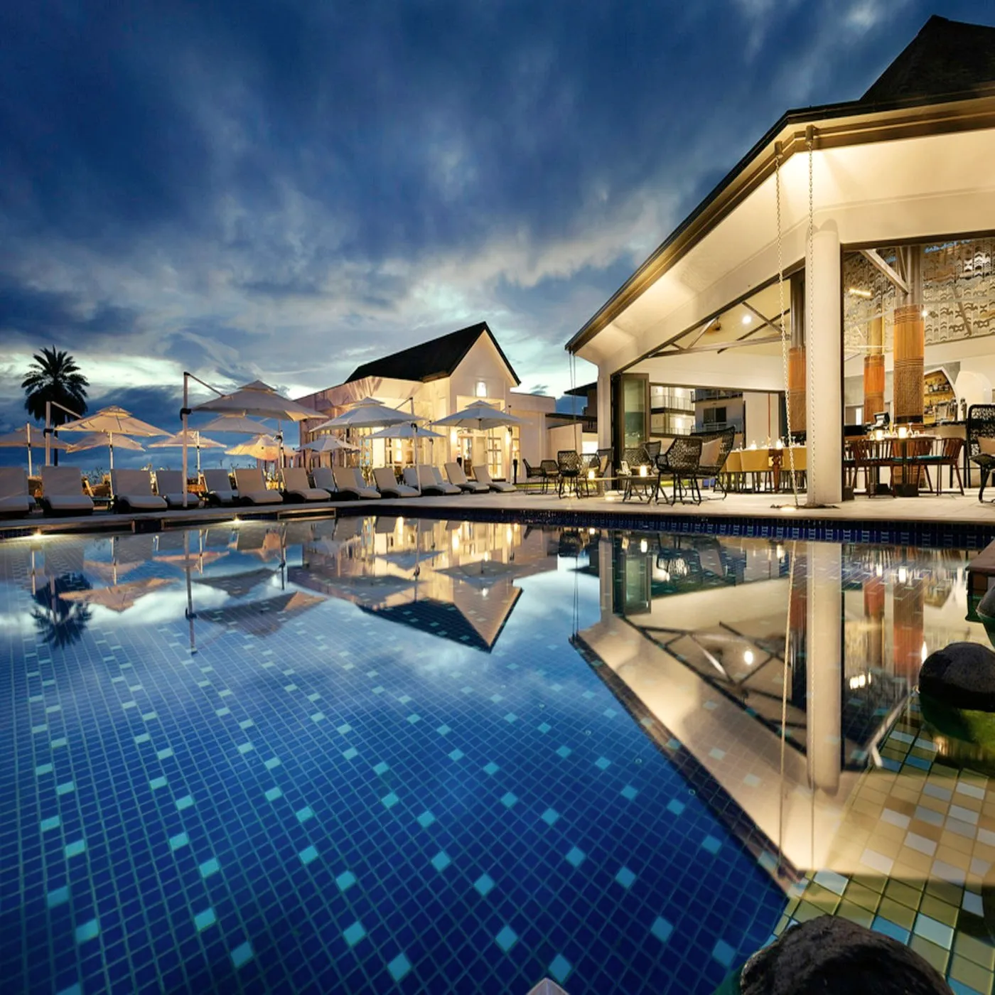 A pool at night reflecting the building.