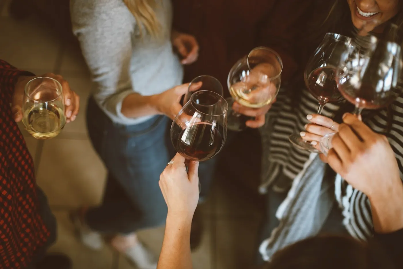 Hands raising wine glasses at a party.