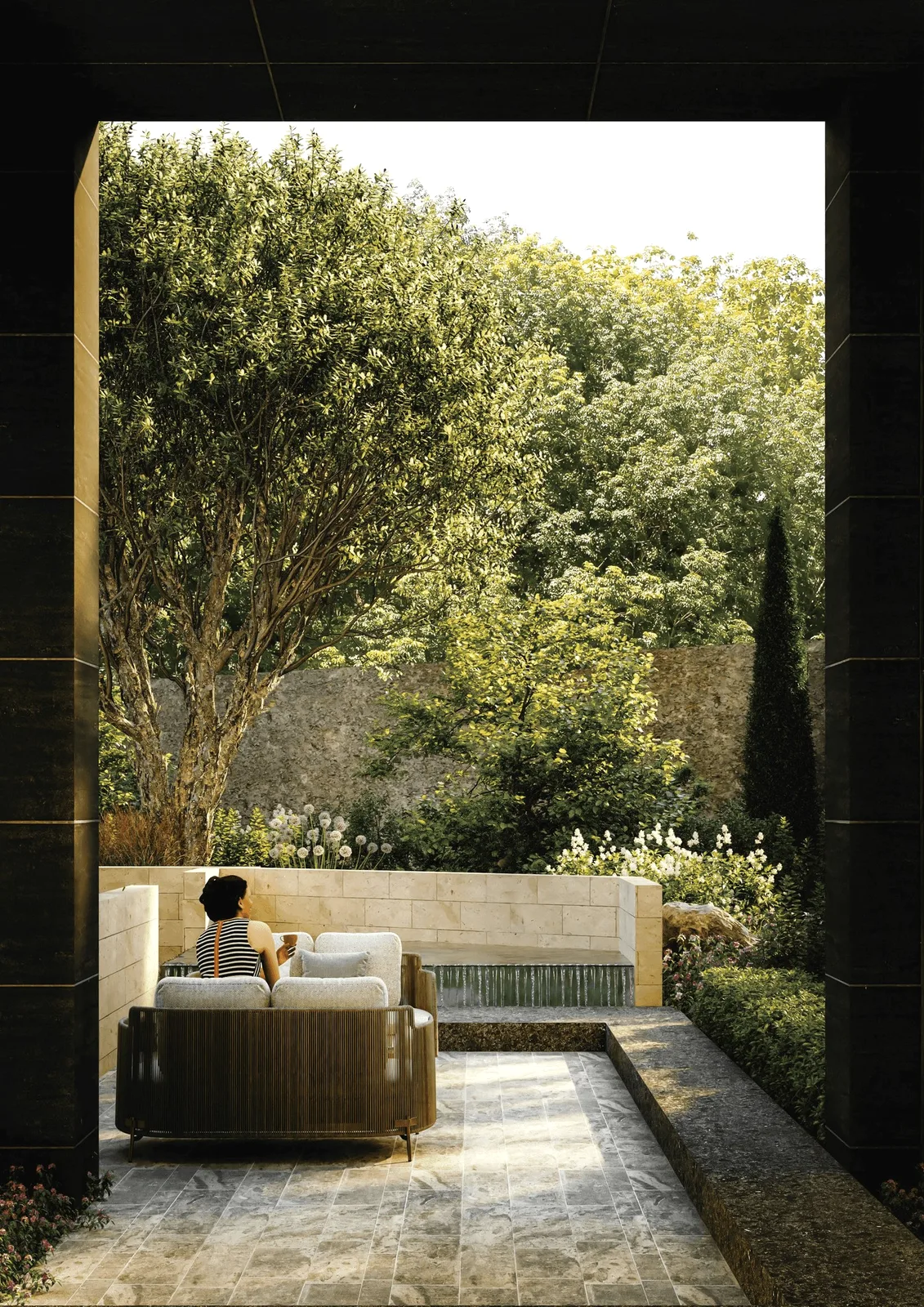 A garden terrace with a sofa, walls and trees around it.