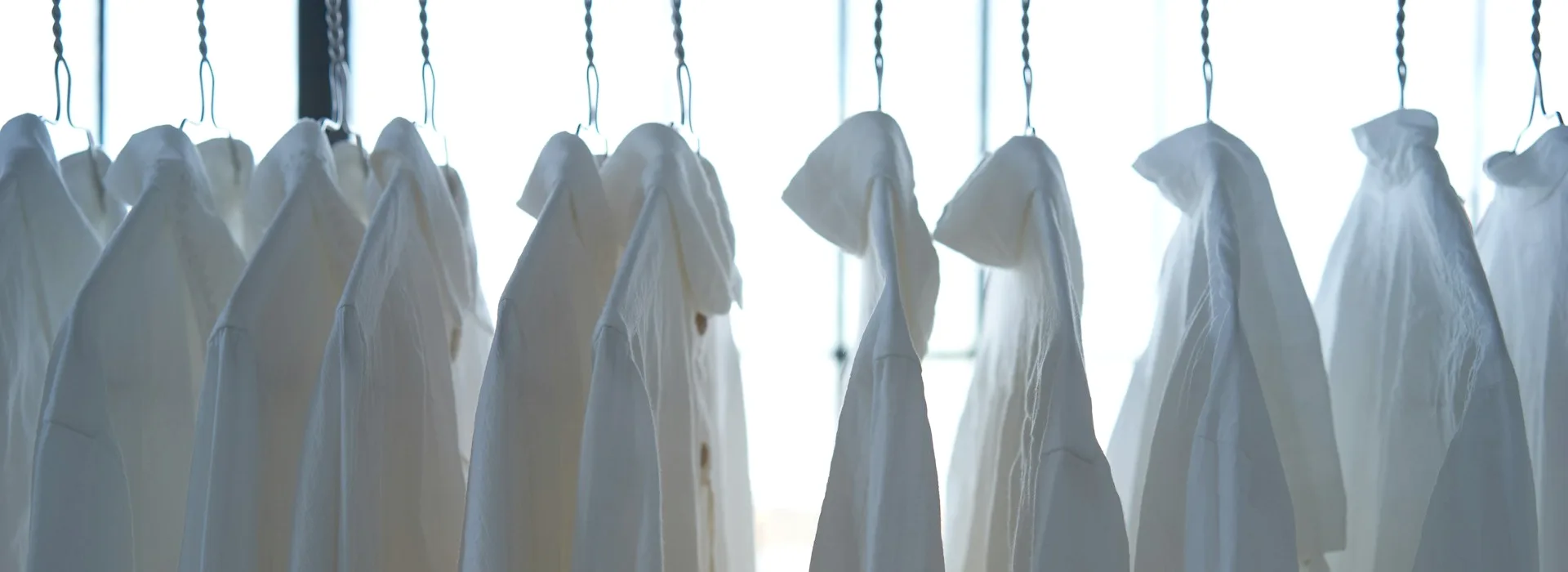 Shirts on hangers along a rail.