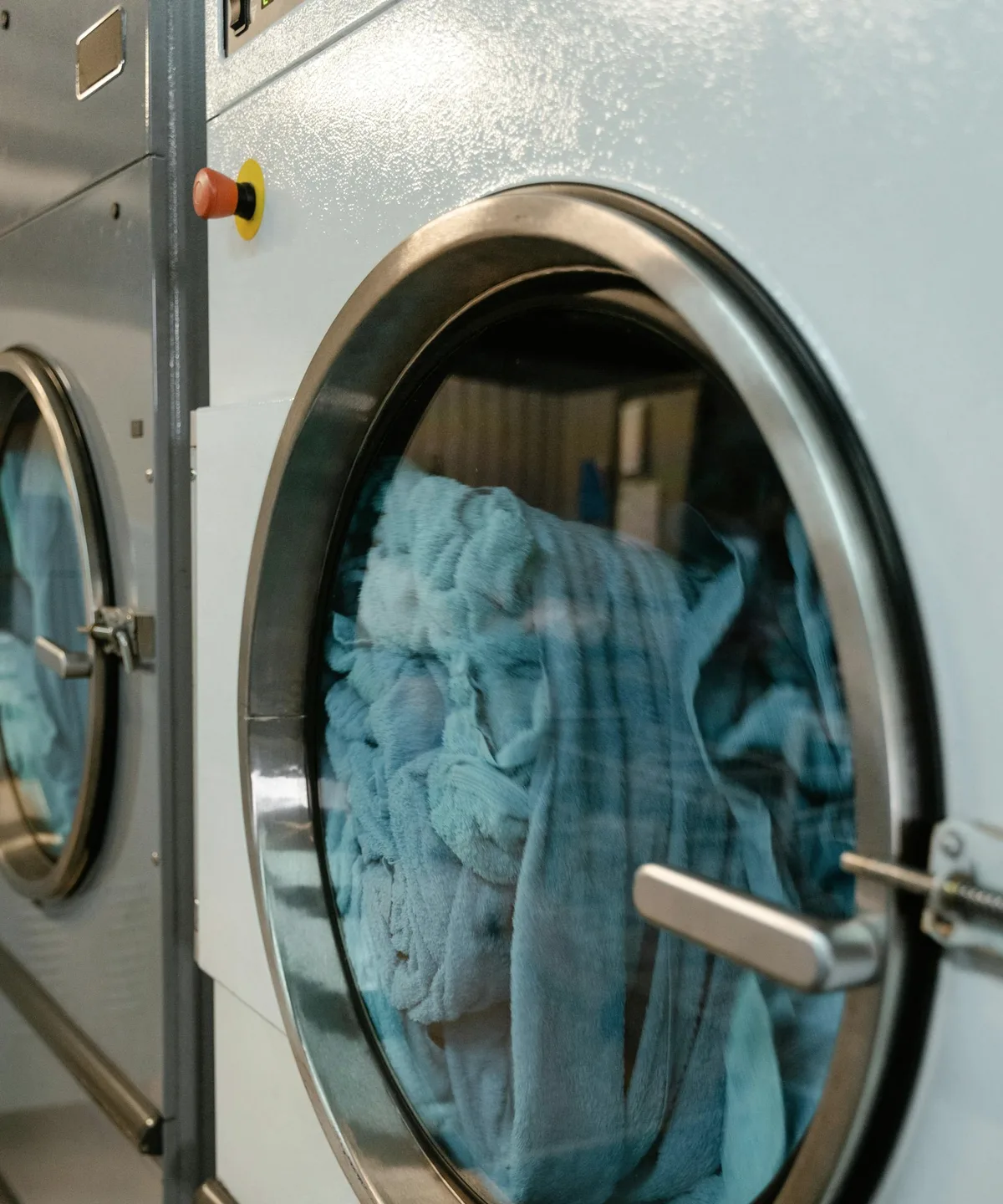 Blue towels in a front-loading dryer drum.
