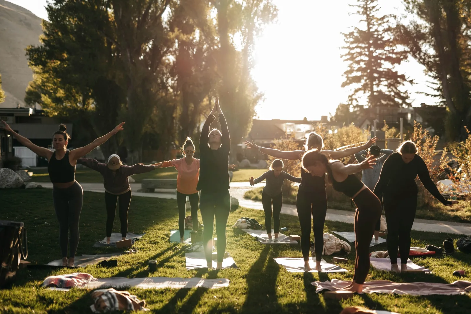 A group practising outdoors on a lawn at golden hour.
